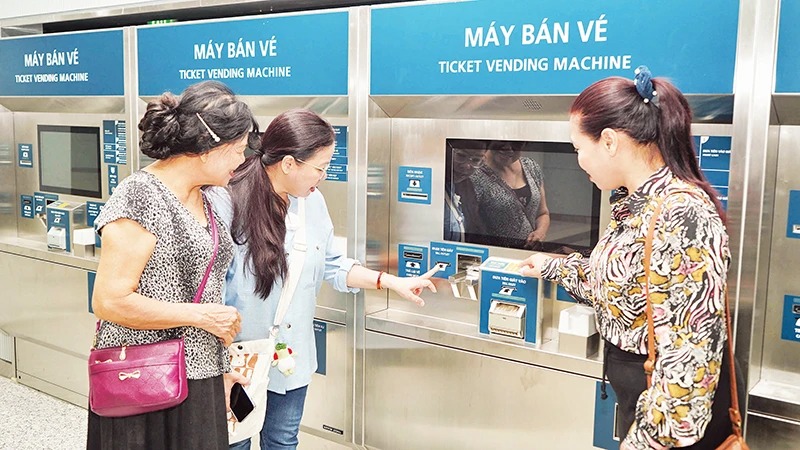 Người dân trải nghiệm tại máy bán vé tự động bên trong ga ngầm Bến Thành, thuộc tuyến Metro số 1. (Ảnh THẾ ANH)